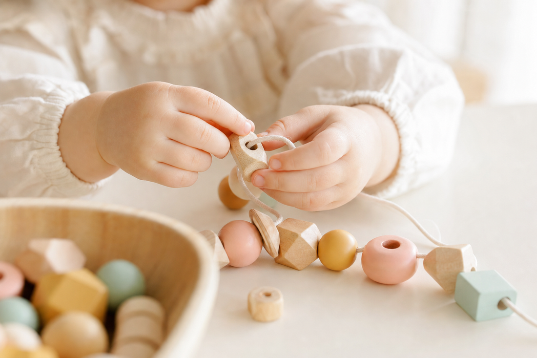 Enfant qui joue avec des perles en bois pour développer la motricité fine